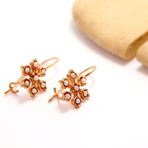 Brincos vintage em formato de estrela, banhados a ouro rosa e prata polida, com pérolas redondas.