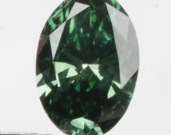 May include: A dark green, oval-cut gemstone held by tweezers. The gem's facets catch the light, displaying its rich colour. The gemstone is set against a white background.