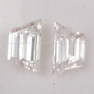 May include: Two clear, faceted, rectangular-shaped diamonds with pointed corners.