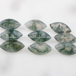 May include: Eight marquise-shaped green moss agate cabochons. The stones have a translucent, cloudy appearance with green and white patterns.