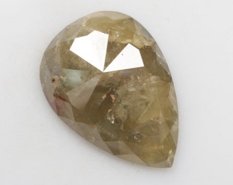 May include: A pear-shaped, faceted, light brown diamond with a rough, natural finish.