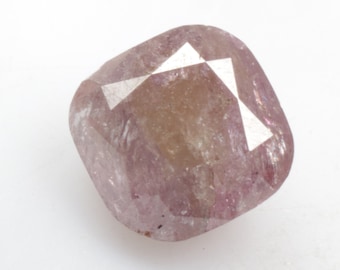 May include: A cushion-cut, pink diamond with a faceted surface. The diamond has a light brown hue and is set in a clear, faceted setting.