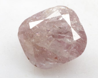 May include: A light pink, faceted, rough cut diamond with a cushion shape.