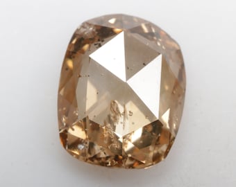 May include: A light brown, faceted, cushion-shaped diamond with inclusions.