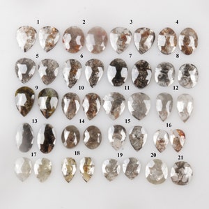 May include: Twenty-one pear-shaped, grey and brown rough diamonds, numbered 1 through 21.