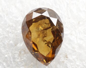 May include: A pear-shaped brown diamond gemstone with a faceted cut.