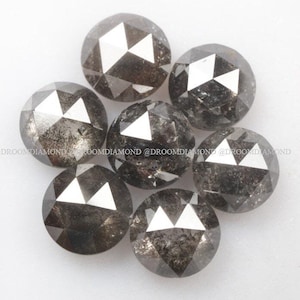 May include: Six round, faceted, black diamonds with a gray tint. The diamonds are arranged in a circle.