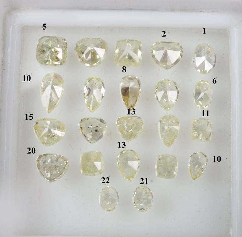 May include: A tray of 22 loose diamonds, each with a unique cut and shape, displayed on a white background. The diamonds are numbered 1 through 22.