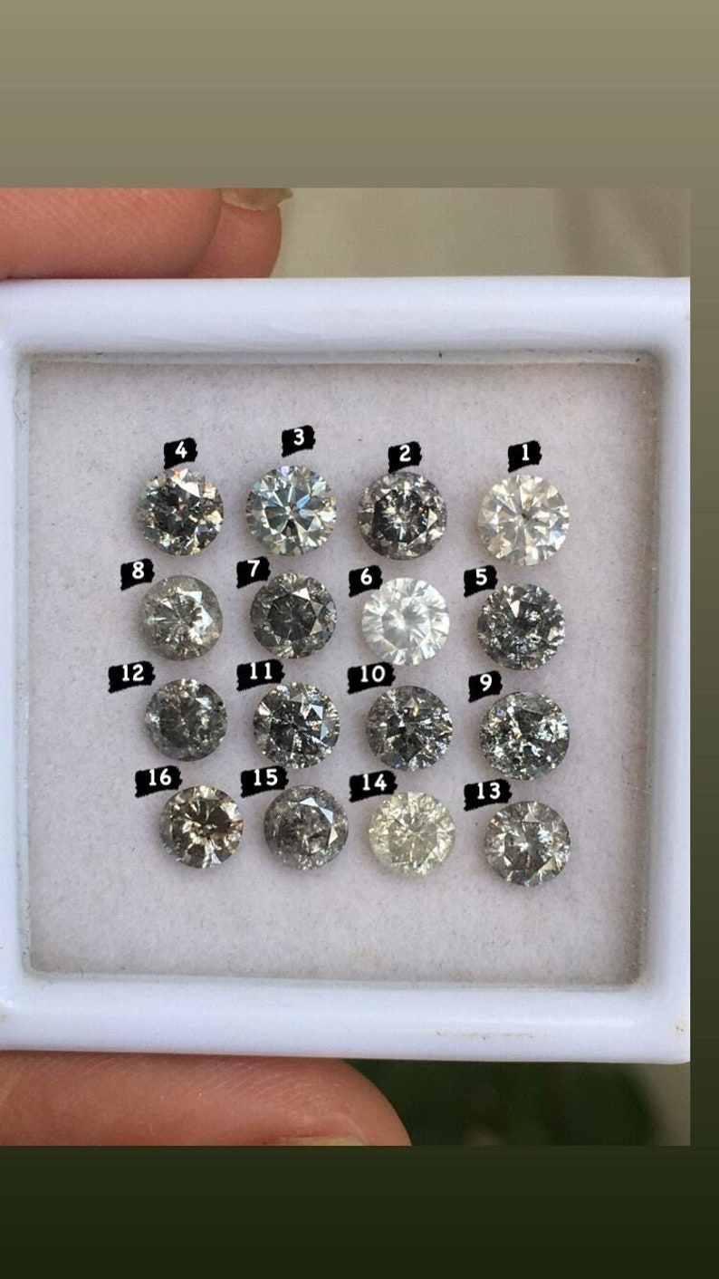May include: A collection of 16 round, gray diamonds in a white box. Each diamond is labeled with a number from 1 to 16.