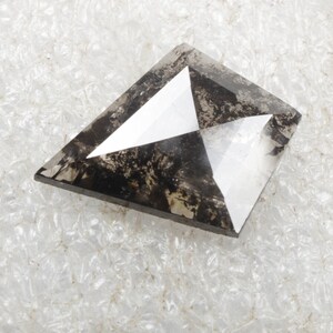 K&ouml;nnte beinhalten: Ein dunkelgrauer, facettierter, drachenf&ouml;rmiger Diamant mit einem klaren Zentrum.