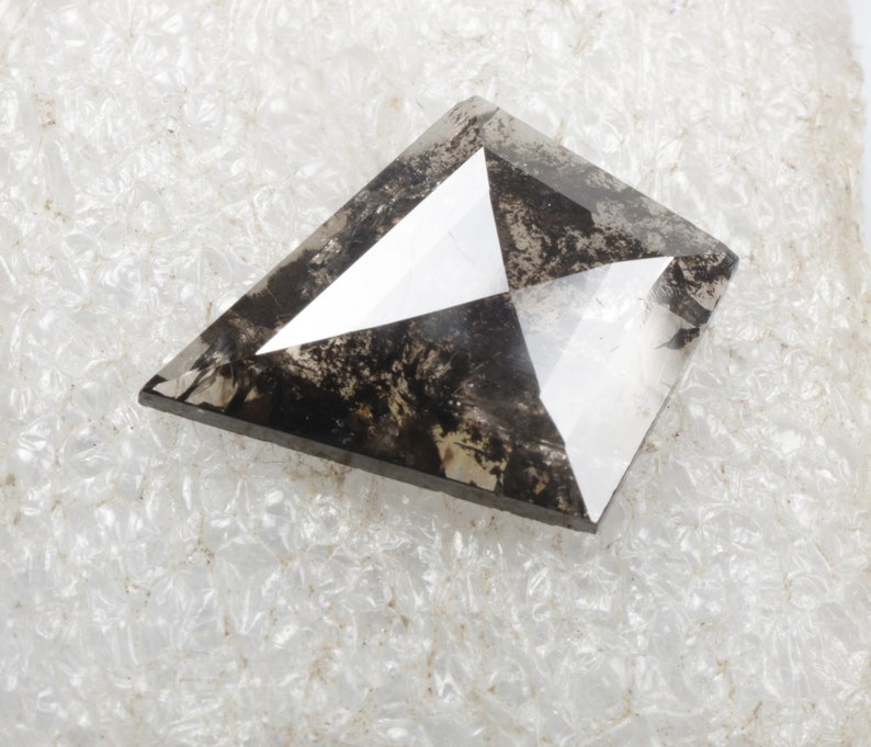 K&ouml;nnte beinhalten: Ein dunkelgrauer, facettierter, drachenf&ouml;rmiger Diamant mit einem klaren Zentrum.
