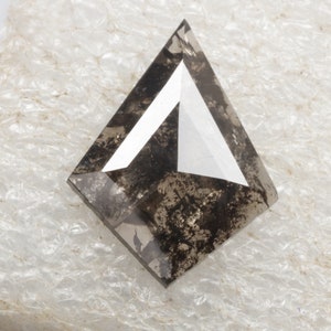 K&ouml;nnte beinhalten: Ein dunkelgrauer, dreieckiger Diamant mit einer wei&szlig;en, dreieckigen Facette in der Mitte.