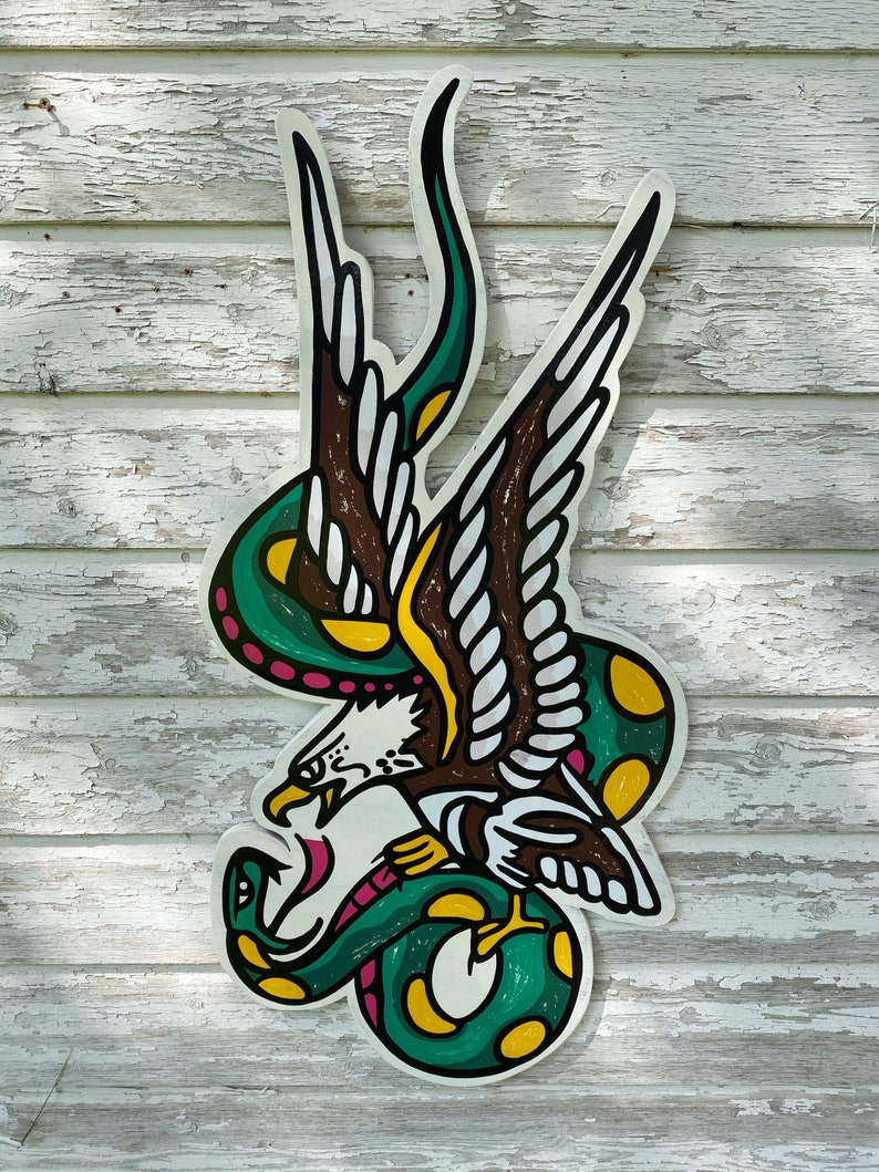 May include: A green snake with yellow spots wraps around a brown and white eagle with its wings spread. The eagle has a red beak and a yellow eye. The snake's tail is curled around the eagle's leg.