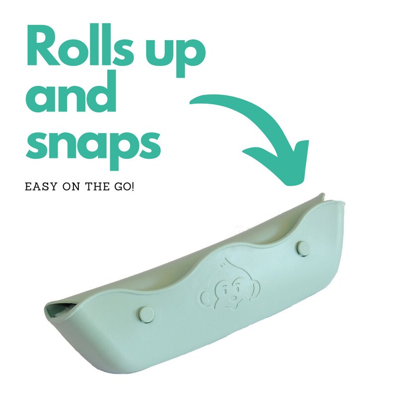 May include: A light green, roll-up baby bib with a monkey face design. The bib has two snap closures and the text "Rolls up and snaps. Easy on the go!" is displayed in the image.