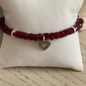 Beautiful Garnet Stretch bracelet with silver heart charm and silver spacer beads.  Add a strand of silver beads to complement.