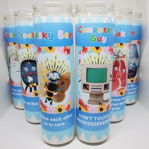 May include: Four glass candle jars with colorful cartoon characters and text. The candles are decorated with a blue, white, and yellow floral pattern. The text on the candles reads "Lote Cloclesky Bee", "Computer Guy", "ak Gmp", and "Love each other is to care. Don't touch meeeeeeeeeeeeee".