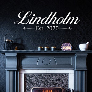 May include: A black fireplace mantel with a white sign that reads "Lindholm Est. 2020".