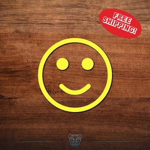 May include: A yellow smiley face on a brown wooden background. The smiley face has two eyes and a mouth.
