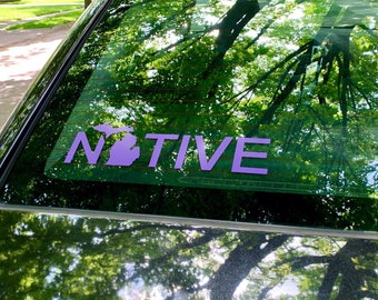 May include: A purple car window sticker with the outline of the state of Michigan and the word "NATIVE" in all caps.