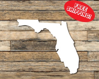 May include: A white outline of the state of Florida against a rustic, wooden background. A red oval with the words "FREE SHIPPING!" is in the upper right corner. The wood has various shades of brown.