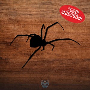 May include: A black spider silhouette with long legs is centered on a wooden background. A red oval with the text "FREE SHIPPING!" is in the upper right corner. The spider is a Halloween or spooky themed item.
