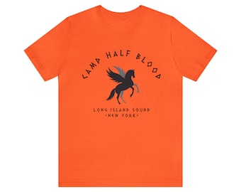 May include: Orange t-shirt with a black and gray winged horse graphic and the text "Camp Half Blood, Long Island Sound, <New York>"