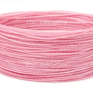May include: A spool of pink waxed cotton cord. The cord is wound tightly and is ready to be used for crafting projects.