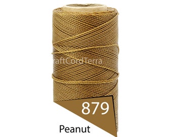 May include: A spool of peanut-colored cord. The cord is tightly wound around a cardboard core. A brown tag displays the number "879" and the word "Peanut". The text "CraftCordTerra" is visible on the cord.