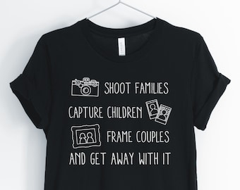 May include: Black t-shirt with white text that reads "Shoot families, capture children, frame couples, and get away with it". The text is accompanied by illustrations of a camera, a photo, and a picture frame.