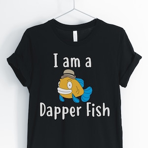 May include: Black t-shirt with a white graphic of a cartoon fish wearing a hat and the text "I am a Dapper Fish".