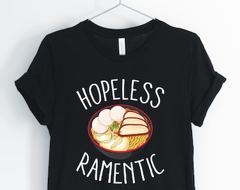 May include: Black t-shirt with white text that reads "HOPELESS RAMENTIC" and a cartoon image of a bowl of ramen noodles.