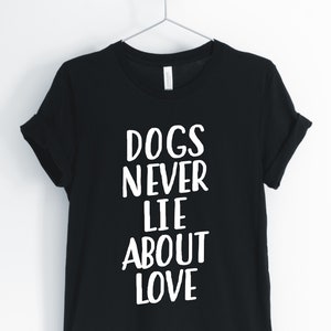 May include: Black t-shirt with white text that reads "Dogs Never Lie About Love".