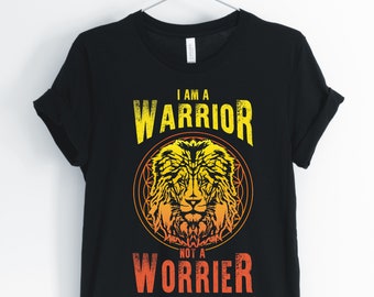 May include: Black t-shirt with a yellow and orange lion graphic and the text "I am a warrior not a worrier".