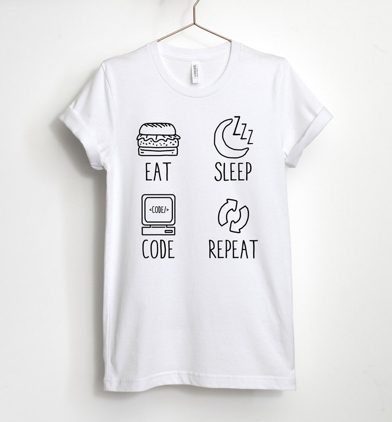 May include: White t-shirt with black text and illustrations. The text reads "Eat, Sleep, Code, Repeat". The illustrations include a hamburger, a crescent moon with zzz's, a computer with code, and a circular arrow.