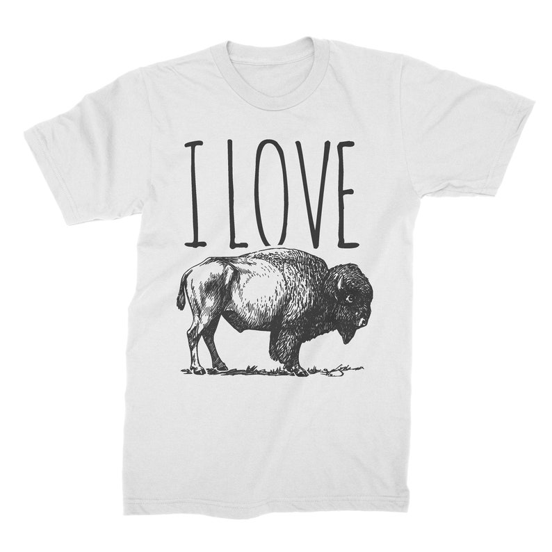 May include: White t-shirt with the text "I LOVE" printed in black above a black and white illustration of a bison.