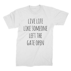 May include: White t-shirt with black text that reads "Live life like someone left the gate open."