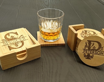May include: Set of four wooden coasters with a personalised initial and name. The coasters are square shaped and have a natural wood finish. The coasters are stacked in a holder.