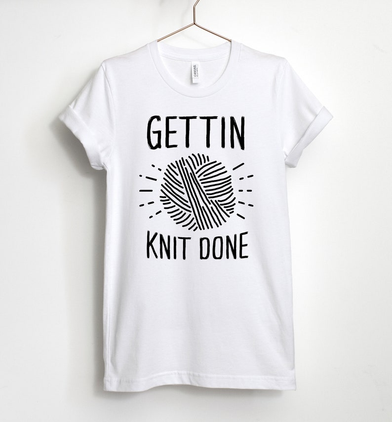 May include: White t-shirt with black text that reads "Gettin' Knit Done" and a graphic of a ball of yarn.