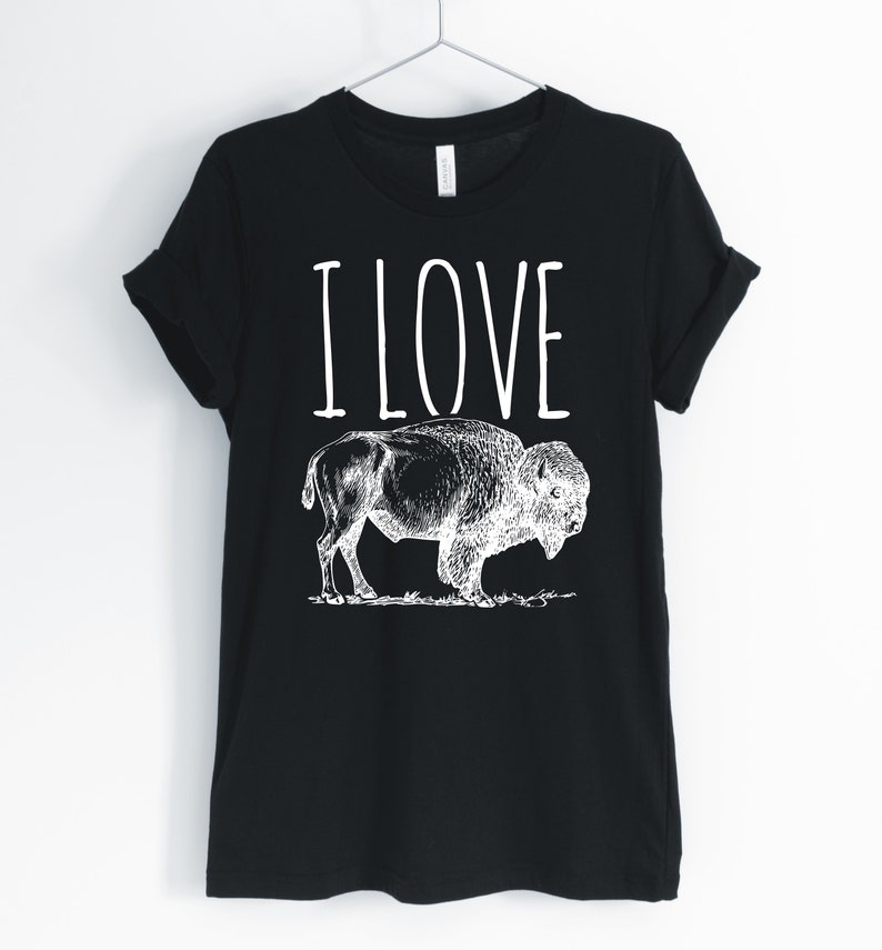 May include: Black t-shirt with white text that says "I LOVE" and a black and white illustration of a buffalo.