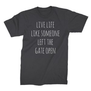 May include: Dark gray t-shirt with white text that reads "Live life like someone left the gate open."