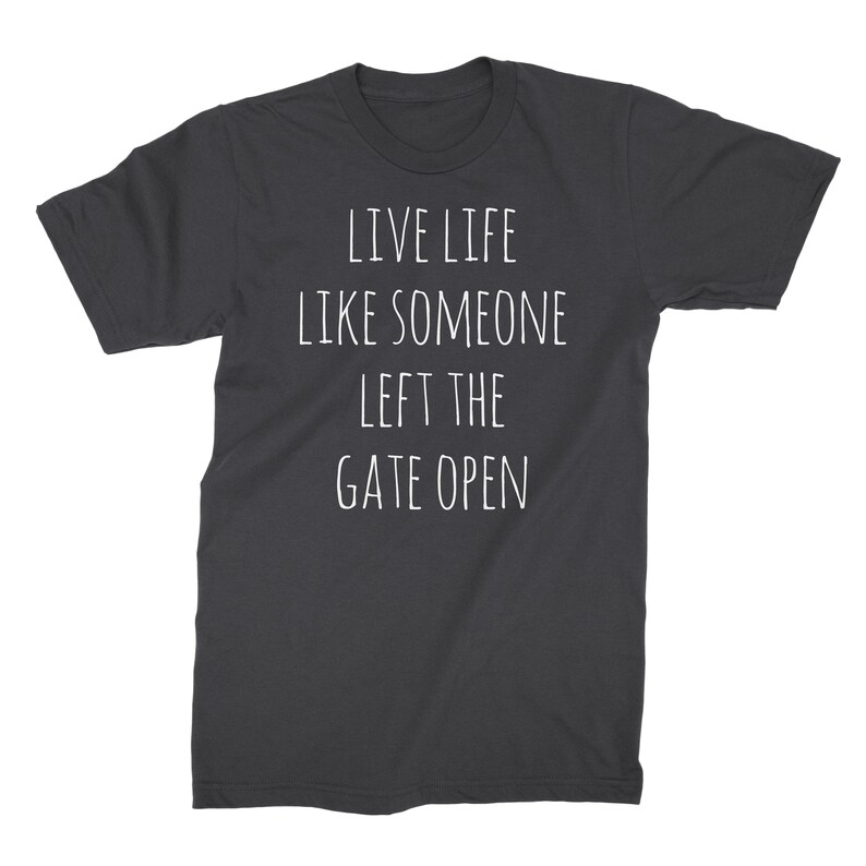 May include: Dark gray t-shirt with white text that reads "Live life like someone left the gate open."