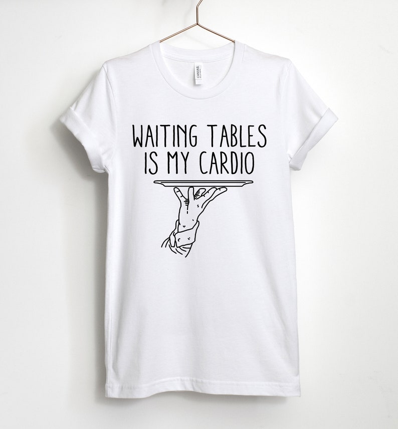 May include: White t-shirt with black text that reads "Waiting tables is my cardio" and a black line drawing of a hand holding a tray.