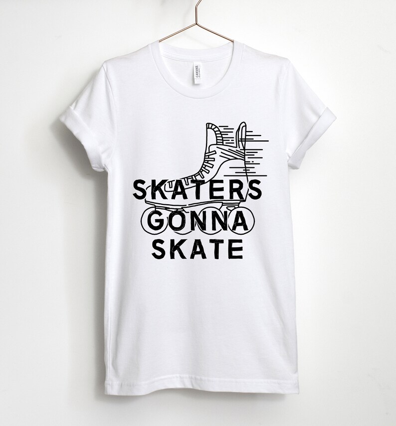 May include: White t-shirt with a black graphic of a roller skate and the words "SKATERS GONNA SKATE". The design features a line drawing of a roller skate with speed lines, and the text is in a bold, sans-serif font.
