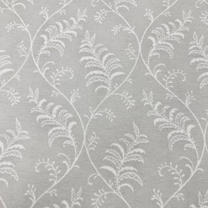 May include: A grey fabric with a white floral pattern. The pattern features delicate fern-like leaves and vines.