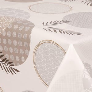 May include: A beige tablecloth featuring a repeating pattern of large, oval shapes in shades of grey and brown. The ovals are filled with various geometric and floral designs. Brown leaf accents are scattered across the surface.