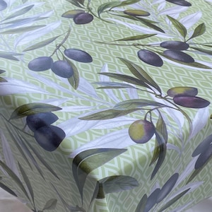 May include: Green tablecloth with a repeating pattern of olive branches and olives. The olives are a mix of green and black.