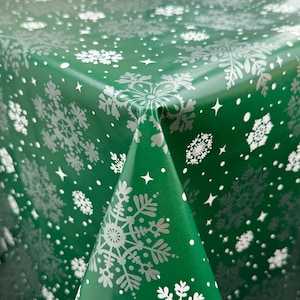 May include: Green tablecloth with a white snowflake pattern. The tablecloth is made of vinyl and is waterproof.