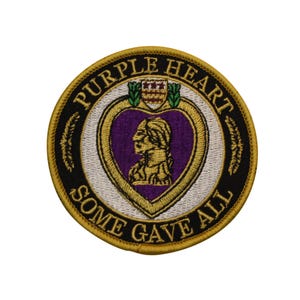 May include: Embroidered patch featuring the Purple Heart medal design. The circular patch has a black border with gold text that reads "PURPLE HEART" and "SOME GAVE ALL." The central design is a purple heart shape with a profile of a person.