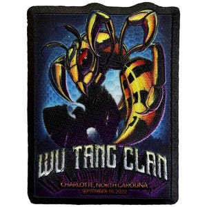 May include: Embroidered patch featuring a stylized wasp with yellow and black stripes, red eyes, and large mandibles. The patch has the text "WU TANG CLAN" and "CHARLOTTE, NORTH CAROLINA SEPTEMBER 18, 2022" in white lettering against a dark blue background.