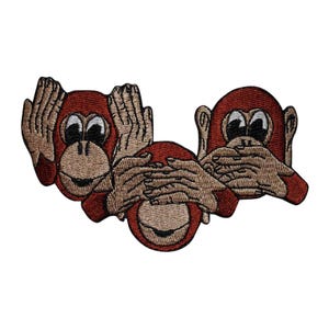 May include: Embroidered patch featuring three cartoon monkeys in a 'see no evil, hear no evil, speak no evil' pose. The monkeys are red with tan hands and faces, and black and white eyes. The patch is designed for application on clothing or accessories.